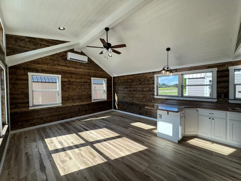 16x38 Tiny Home – Model 9487, great room with dark wood walls and vaulted ceiling